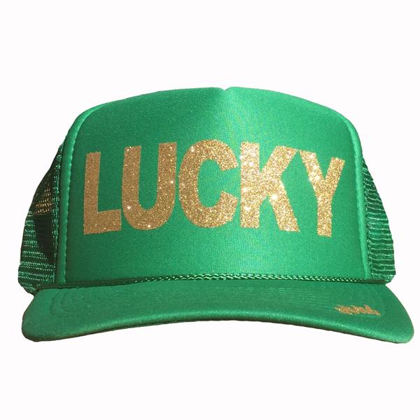 Lucky in glitter gold ink on the front panel of a classic mesh kelly green trucker cap with an adjustable snapback