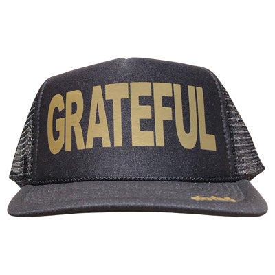 Grateful in gold ink on the front panel of a black mesh trucker cap with an adjustable snapback