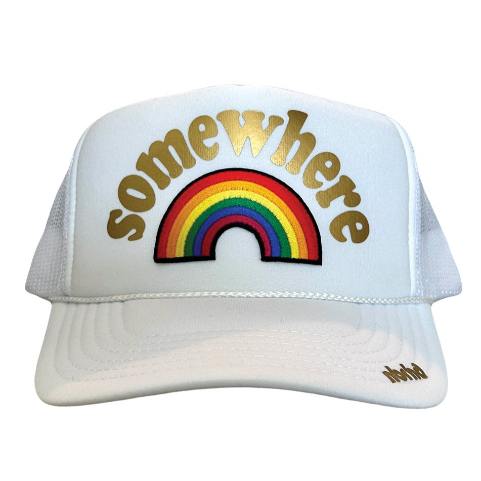 White classic trucker hat with Somewhere in gold over rainbow patch