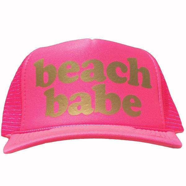 Beach Babe in gold ink on the front panel of a classic mesh pink trucker cap with an adjustable snapback