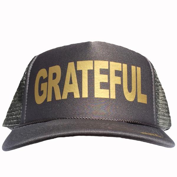 Grateful in gold ink on the front panel of a charcoal mesh trucker cap with an adjustable snapback