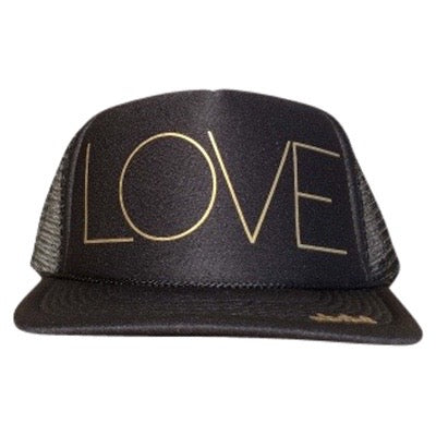 LOVE in gold ink on the front panel of a classic mesh black trucker cap with an adjustable snapback