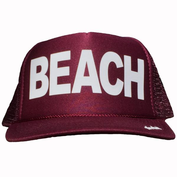 BEACH in white ink on the front panel of a classic mesh maroon trucker cap with an adjustable snapback