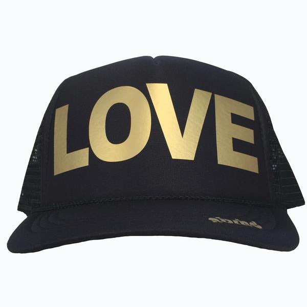 LOVE in gold ink on the front panel of a classic mesh black trucker cap with an adjustable snapback